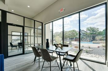 a dining room with a table and chairs in front of a large window  at Carmel Creekside, Texas